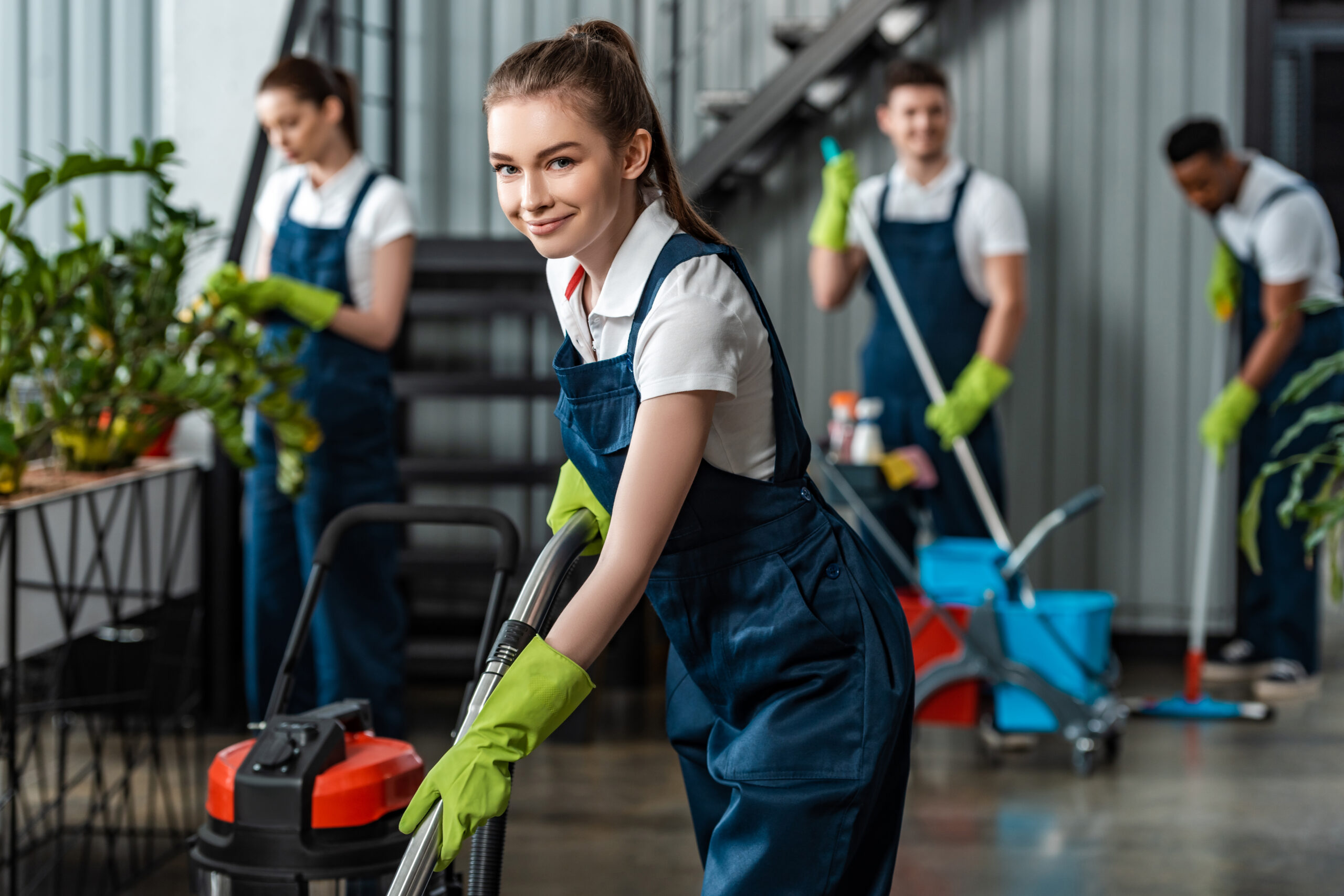 smiling cleaner vacuuming floor in office near mul 2026 01 06 00 28 25 utc