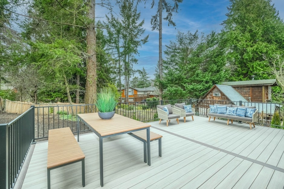 Beautiful wooden patio deck with outdoor furniture and chairs in a backyard setting