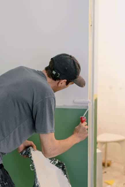 Professional painter carefully cutting in along crown molding